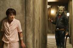 The Grabber (Ethan Hawke) holding an axe while stalking Gwen (Madeleine McGraw) in Black Phone 2